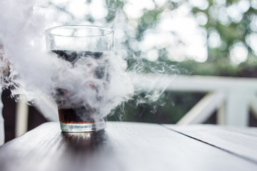 A glass of cola with smoke inside