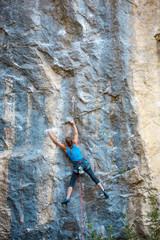 The girl climbs the rock.
