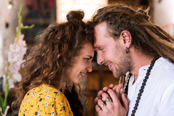 Feeling support. Curly happy woman feeling great support of her husband while hugging and looking...