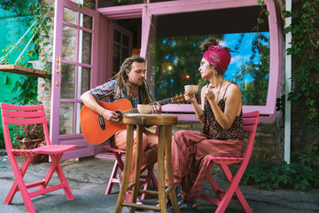 Creative musicians. Couple of creative musicians wearing bright clothes drinking tea and playing...