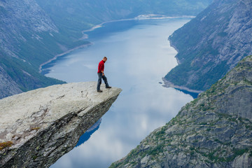 Man in blue sportswear standing on trolltunga in Norway.