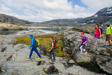 Group of seven mountaineer hiker walking on rocky terrain five members team sport clothing Climbing...
