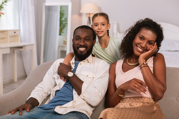 Happy family. Positive nice family looking at you while spending their day together