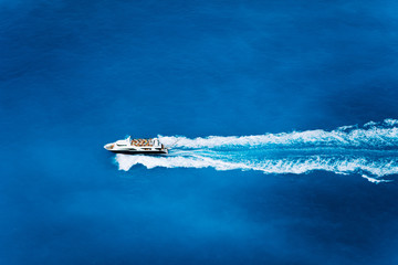 Obraz premium Aerial top view of tourist speed boat sailing in the deep blue sea