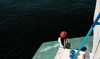 A girl in a red hat at sea