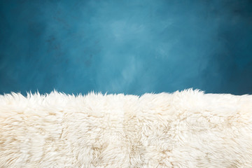 white fur carpet and blue painted wall
