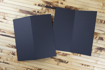 Mockup of black booklet on bamboo background.