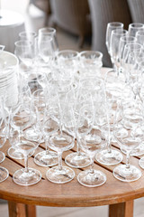 Clean plates, glasses and cutlery on wooden table. Catering set-up ready for the event to begin. ervice area the waiter in restaurant.