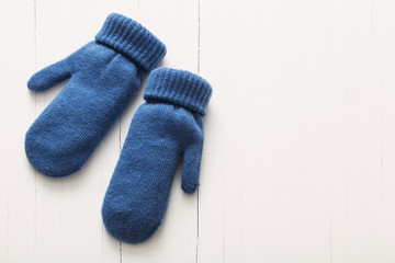 blue mittens on white wooden background