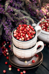 Cowberry berries in dishes. Concept autumn, health, longevity, natural medicine.