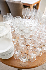 Clean plates, glasses and cutlery on wooden table. Catering set-up ready for the event to begin. ervice area the waiter in restaurant.