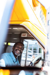 happy mature african american bus driver looking at camera
