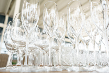 Clean plates, glasses and cutlery on wooden table. Catering set-up ready for the event to begin. ervice area the waiter in restaurant.