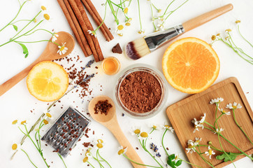 Preparing Homemade skin care treatment products, set of different ingredients viewed above white table. Cocoa powder, orange, chamomile, cinnamon. Organic cosmetics.