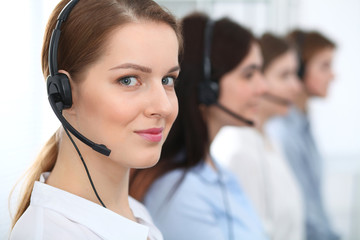 Call center. Beautiful cheerful smiling operator consulting clients with headset. Business concept...