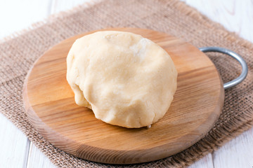 Raw wheat dough on cutting board