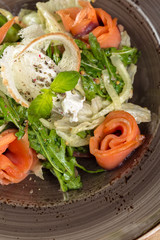 Red fish healthy salad with mixed lettuce leaves