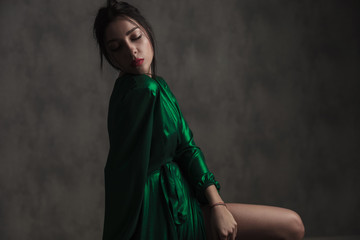 side view of beautiful woman in green dress posing sensually