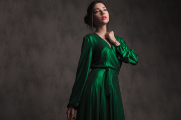 dreamy girl wearing a green gown looks up to side