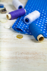 Fototapeta na wymiar Sewing accessories and blue fabric
