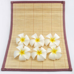 White flowers on bamboo sheets .