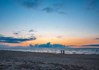 Fototapeta na wymiar sonnenuntergang am strand in jurmala mit silhouetten von personen