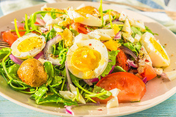 German food - vegetable salad with boiled egg on plate on rustic background