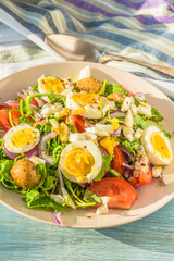 Mediterranean salad with tomatoes, arugula, potatoes and boiled eggs
