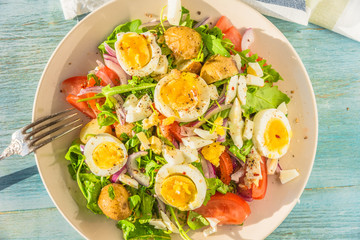 Mediterranean salad with tomatoes, arugula, potatoes and boiled eggs