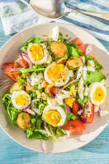 Mediterranean salad with tomatoes, arugula, potatoes and boiled eggs