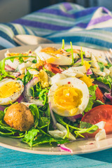 Mediterranean salad with tomatoes, arugula, potatoes and boiled eggs