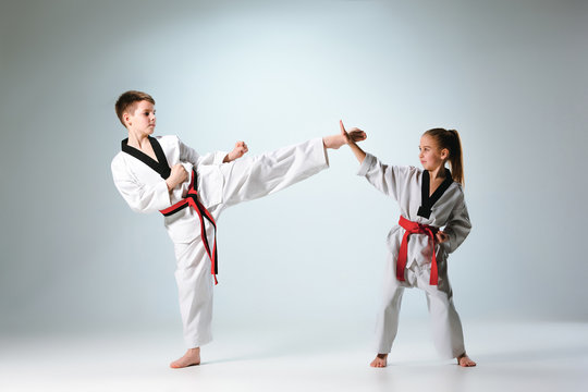 The studio shot of group of kids training karate martial arts on gray backlground