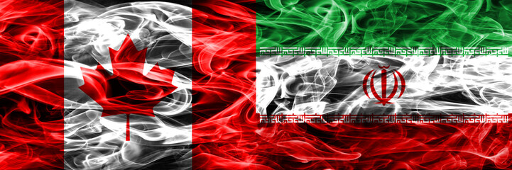Obraz premium Canada vs Iran smoke flags placed side by side. Canadian and Iran flag together