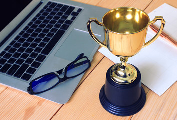 Trophy and planing book on working table , winner concept.