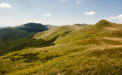 Fototapeta premium Scenic view of grassland mountain hills during sunny day