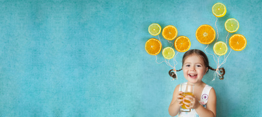 Smiling girl drinks fresh orange juice
