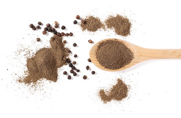 Ground black pepper powder and grains in wooden spoon, isolated on white background, top view