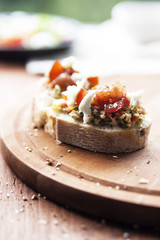 Mozzarella cheese, cherry tomatoes and arugula pesto bruschetta on light background, top view. Arugula pesto and sandwiches - tasty snack, snack, tapas
