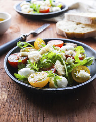 Fresh summer salad with mixed colour cherry tomatoes, lettuce, arugula and mozzarella cheese
