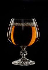 A glass of cognac on a black background close-up