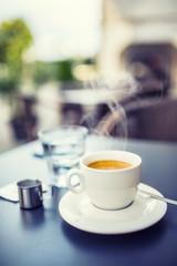 Fototapeta na wymiar Cup of coffee on table in restaurant terrace