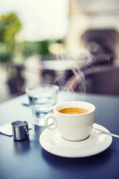Fototapeta Cup of coffee on table in restaurant terrace