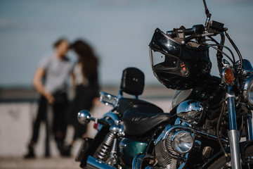 selective focus of classical motorcycle with bikers on background