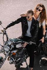 Obraz na płótnie Canvas two bikers sitting on classical cruiser motorcycle on asphalt road
