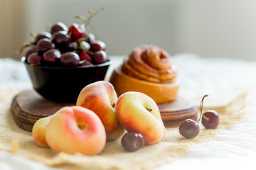 Homemade cinnamon buns in glaze on a dark plate with berries