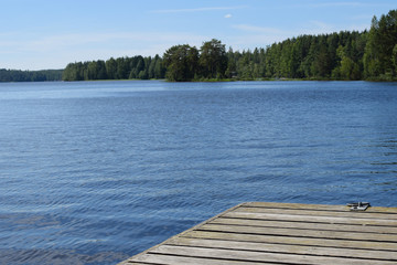 Beautiful lake in Savonia, Finland and part of wooden pier.