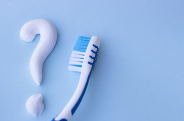 Question mark from toothpaste on blue background, toothpaste selection concept