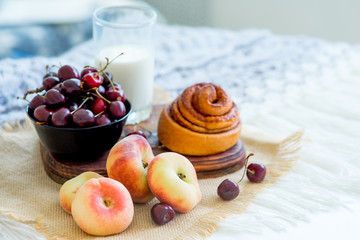 Homemade cinnamon buns in glaze on a dark plate with berries