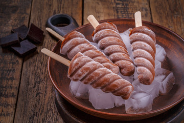 Homemade chocolate ice popsicles.  Chocolate ice-cream close-up on wooden table.