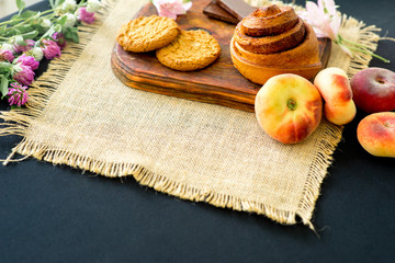 Homemade cinnamon buns in glaze on a dark plate with berries